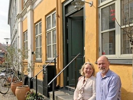 Ægteparret Jane Kjølbye og Thomas Møller på bænken foran deres hus i Slottensgade, hvor de også har sat træer i krukker op.